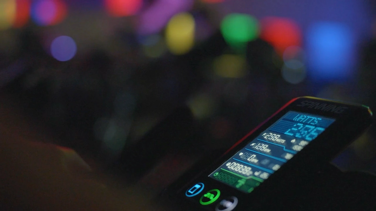 An indoor cycling bike display showing workout metrics under the studio lights.