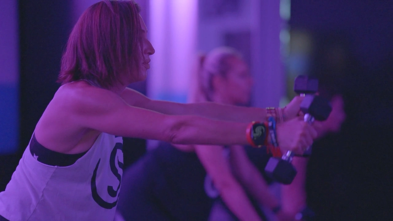 Studio Spin members lifting dumbbells together during class.