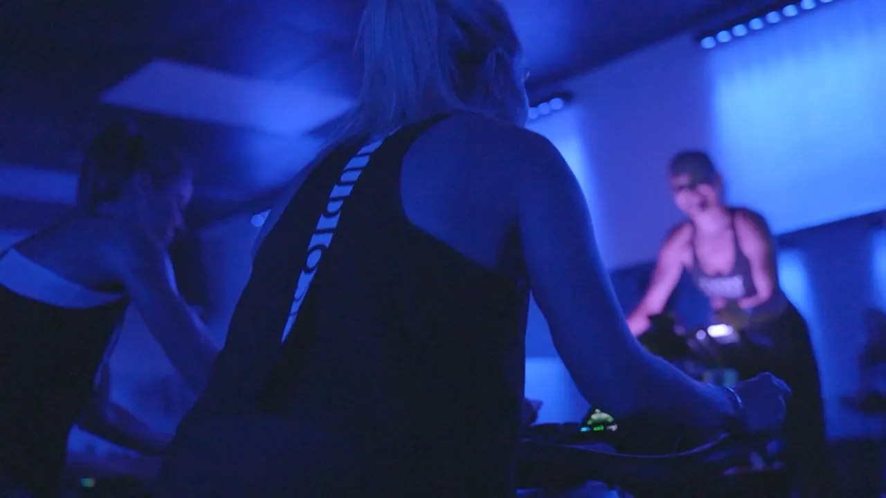 Studio Spin members riding together under blue studio lights