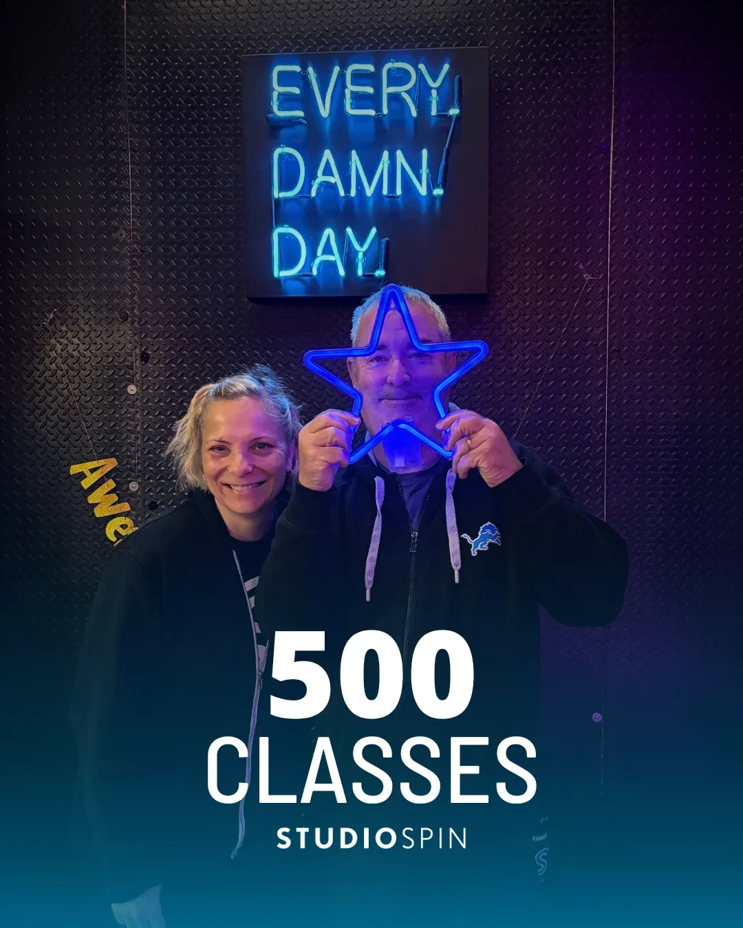 A Studio Spin member celebrating 500 classes under the Every Damn Day neon sign.
