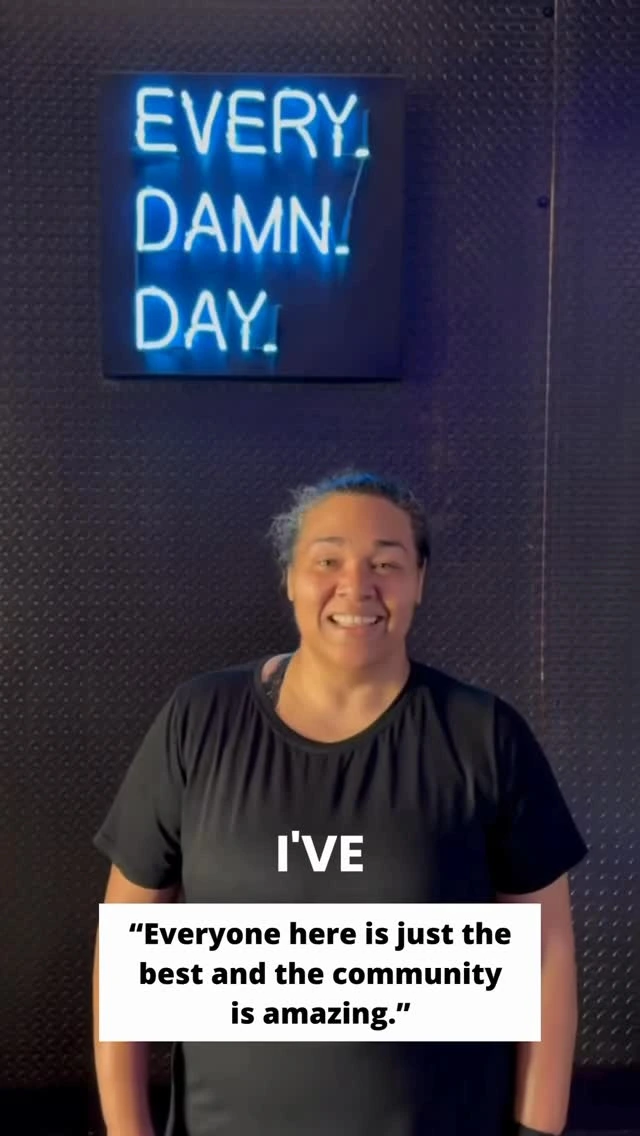 A Studio Spin member sharing a testimonial beneath the Every Damn Day neon sign.