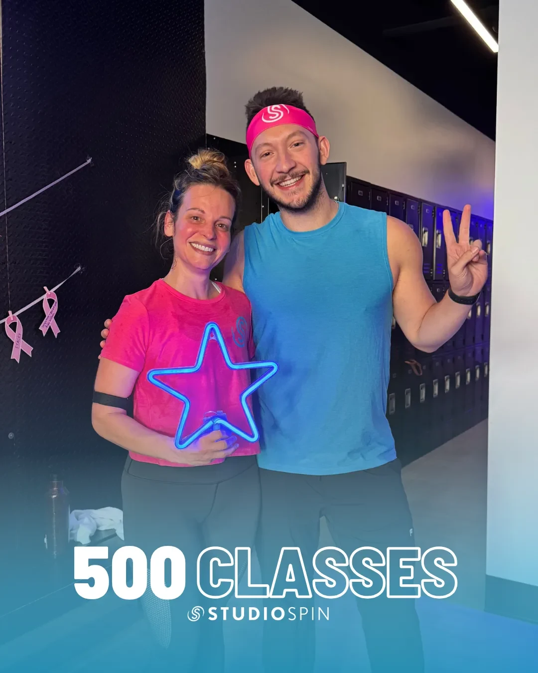 A Studio Spin member celebrating 500 classes under the Every Damn Day neon sign.
