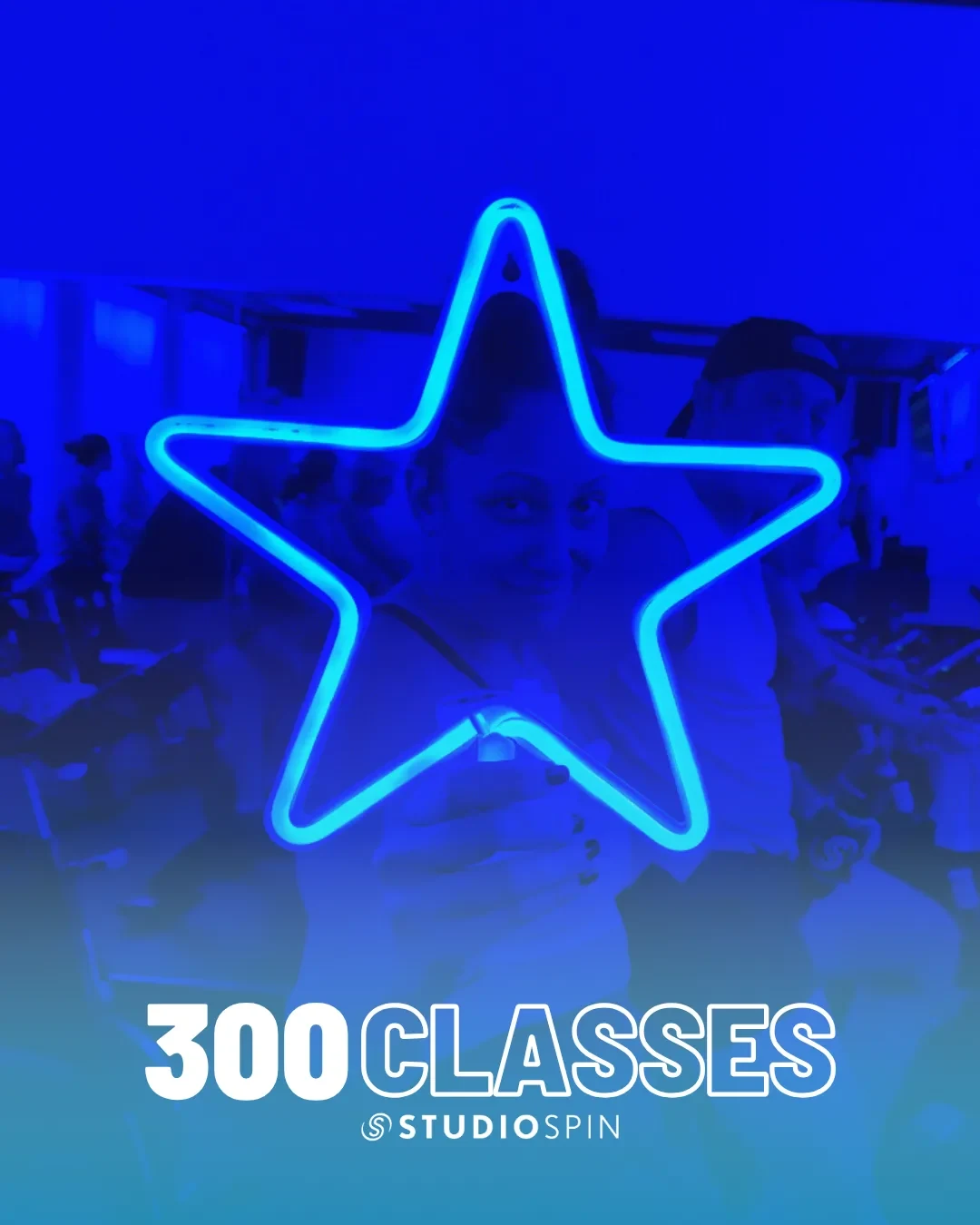 A Studio Spin member celebrating 300 classes under the Every Damn Day neon sign.