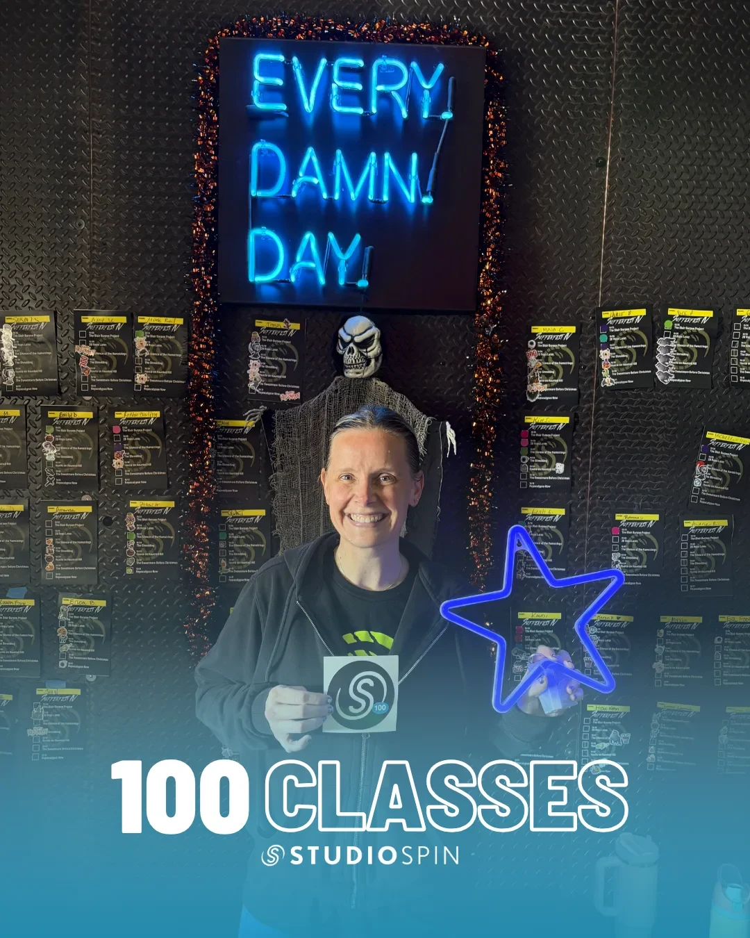 A Studio Spin member celebrating 100 classes under the Every Damn Day neon sign.