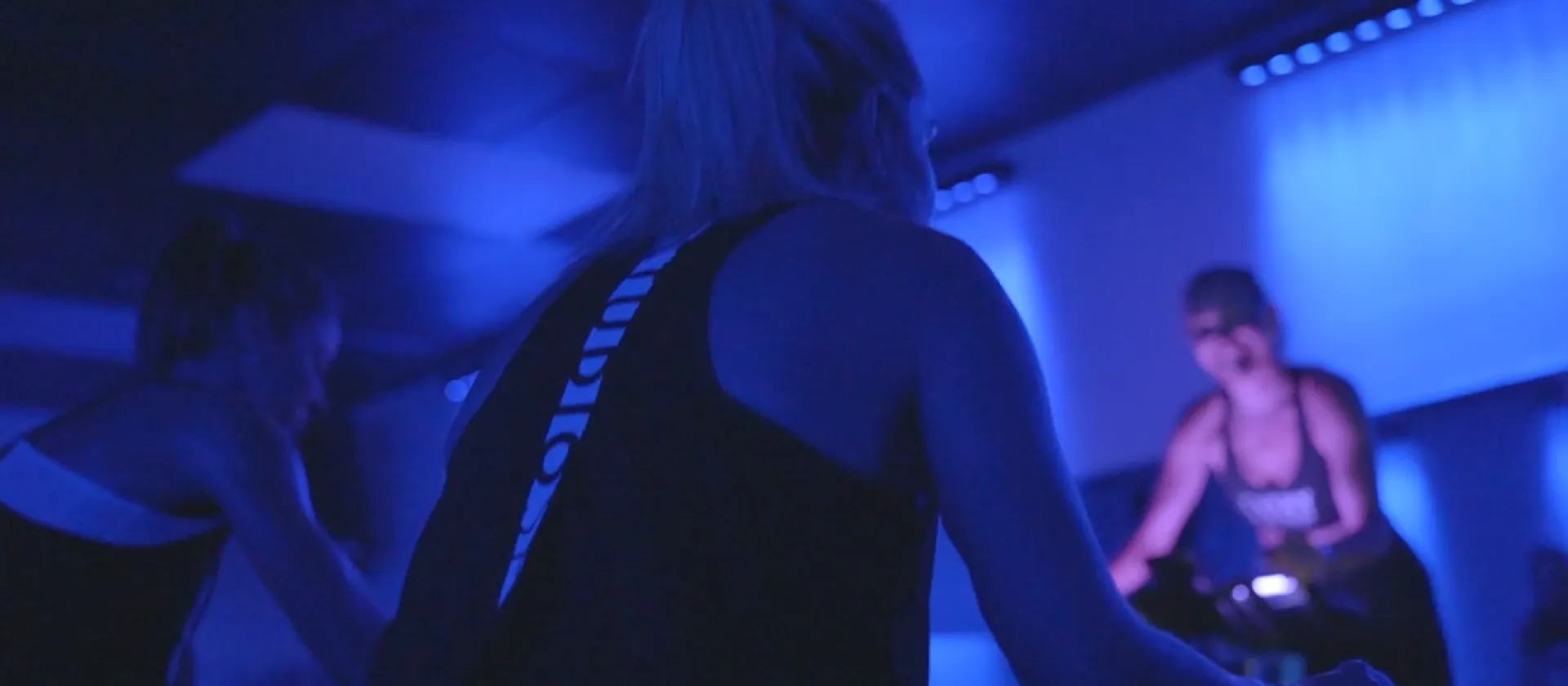 Studio Spin members combining indoor cycling with Pilates-inspired mat work.
