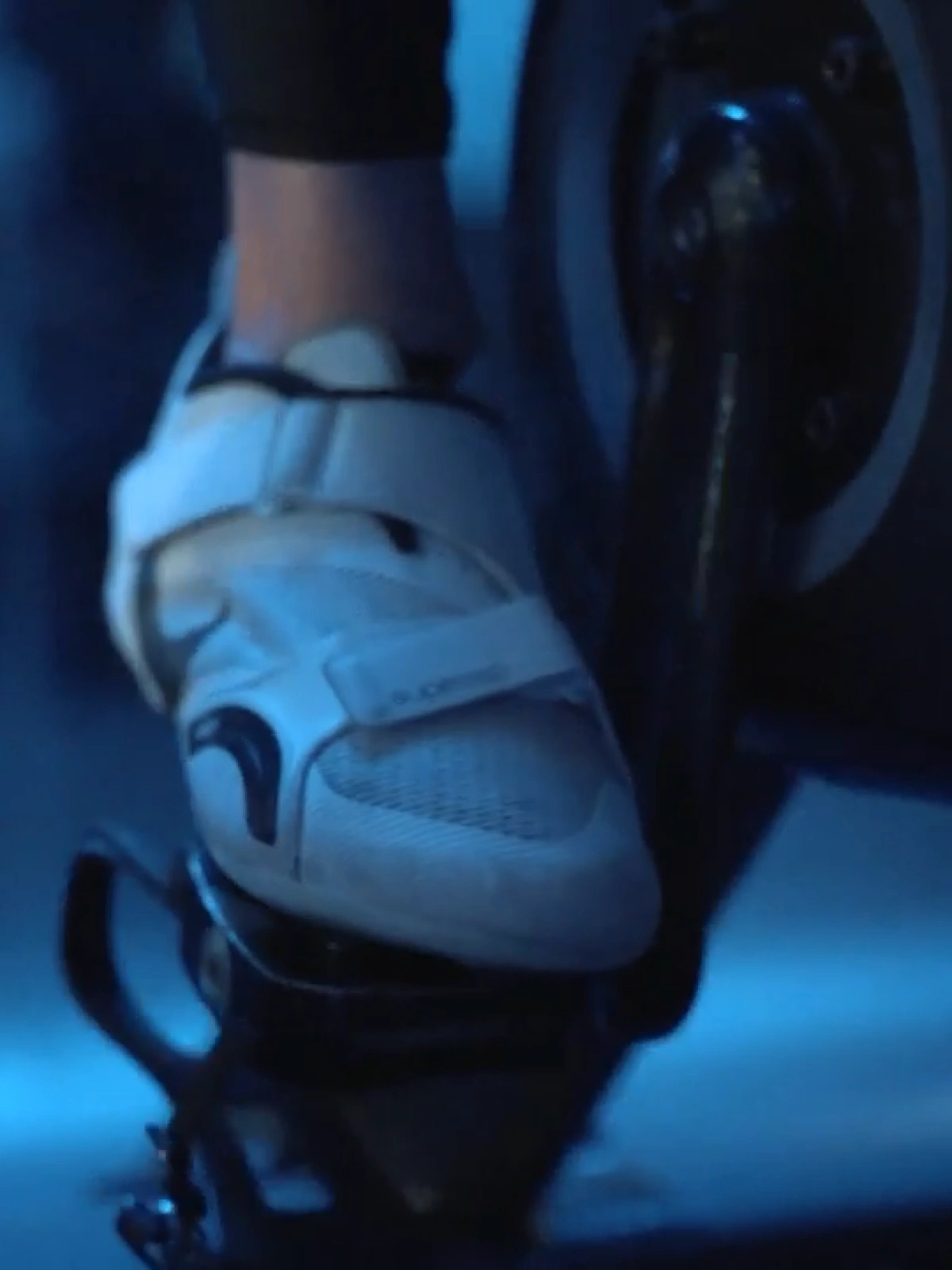 A Studio Spin rider pedaling an indoor cycle bike.