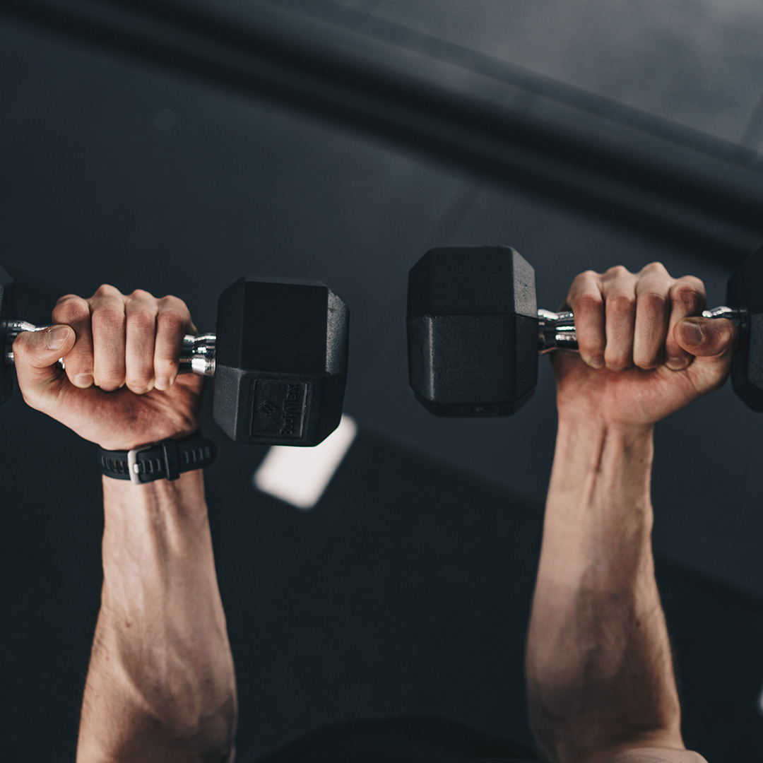 A top view of a man with free weights doing arm curls