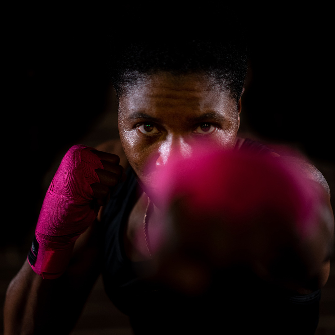 A fitness instructor with pink tape on her hands